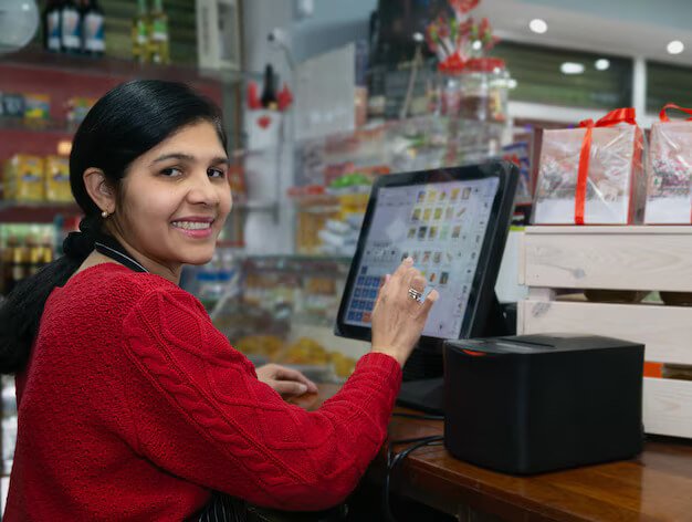 A smiling woman using a touchscreen POS system in a retail store.