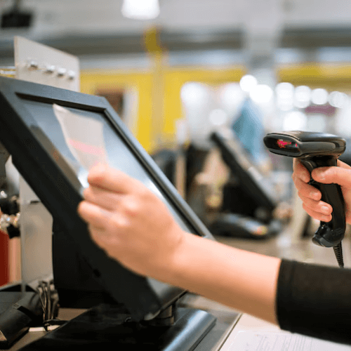 Person using a POS system with a barcode scanner.